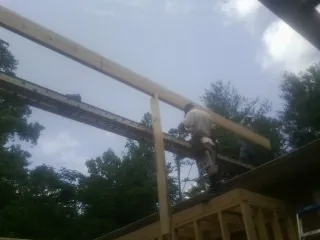 Carpenter setting a ridge beam over a new addition frame — Ice Dam Removal by Roofing Brothers in Alder