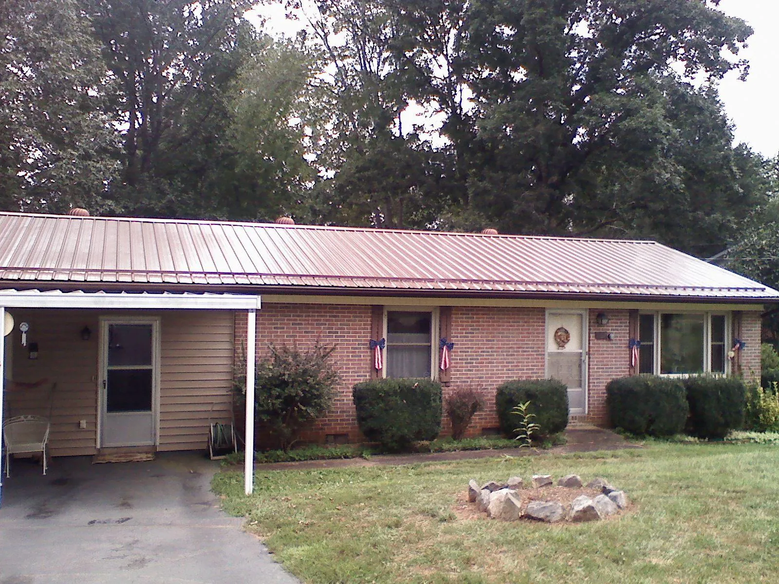 Bronze metal roof and carport on a brick ranch home — Roof Repair work by our crew in Alder
